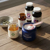 Various health supplements including a jar of collagen, bottles, and capsules on a wooden surface.