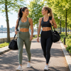 Two women in athletic wear walking outdoors with trees and water in the background