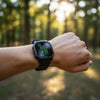 Person wearing a smartwatch with a forest background